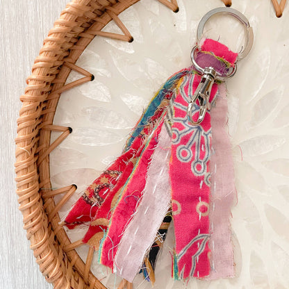 Colorful fabric keychain with a woven basket on a textured surface