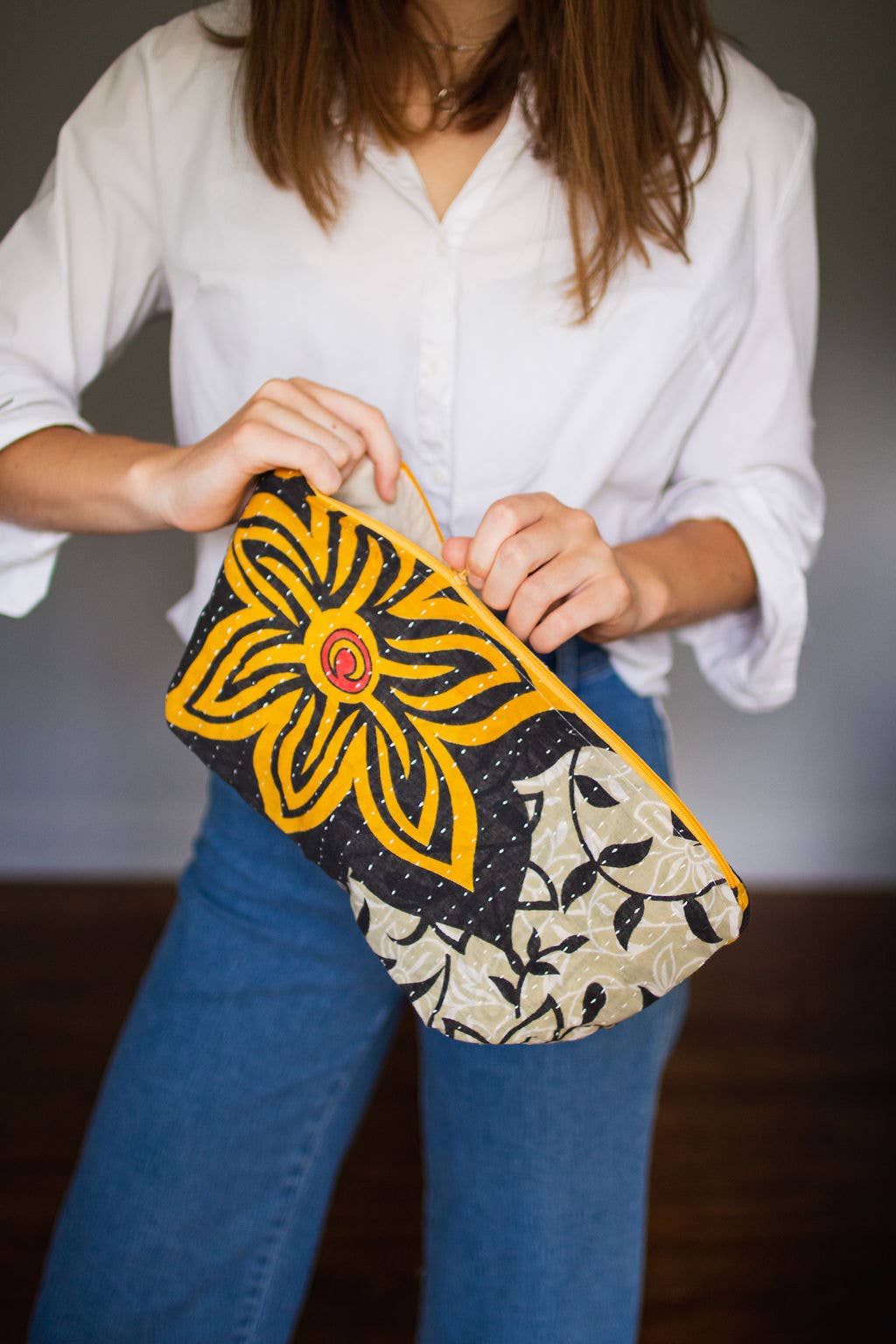Person holding a colorful large clutch bag with floral design