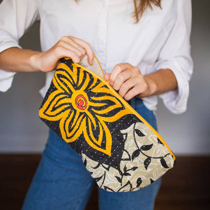 Person holding a colorful large clutch bag with floral design