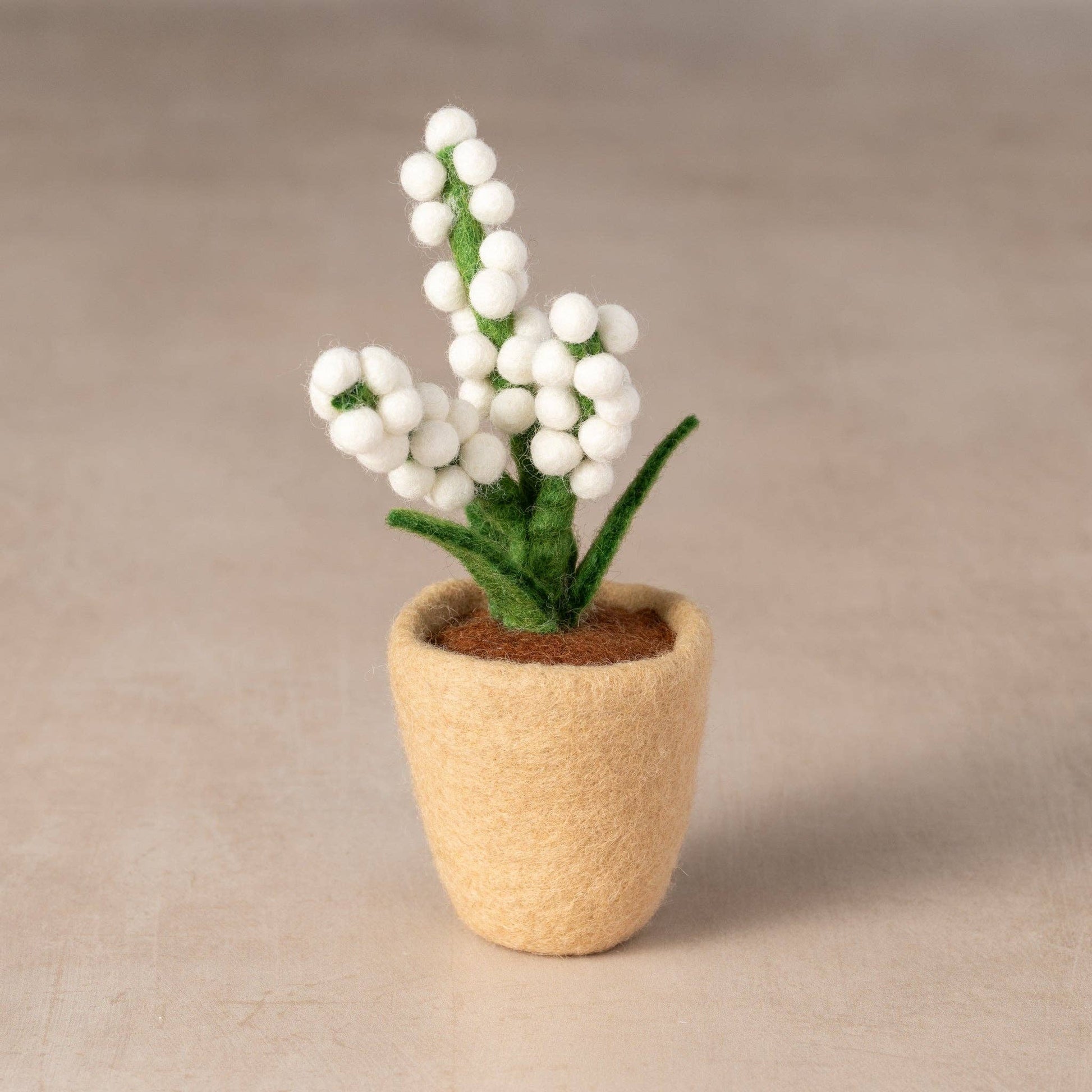 Felted wool flower pot with three white Baby’s Breath stems in a soft tan base