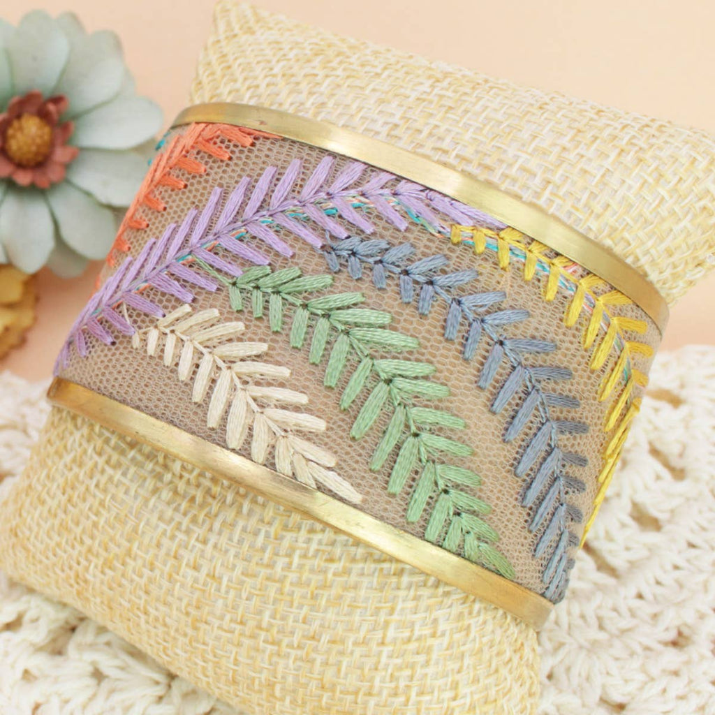 Decorative bracelet with embroidered pattern on a textured surface