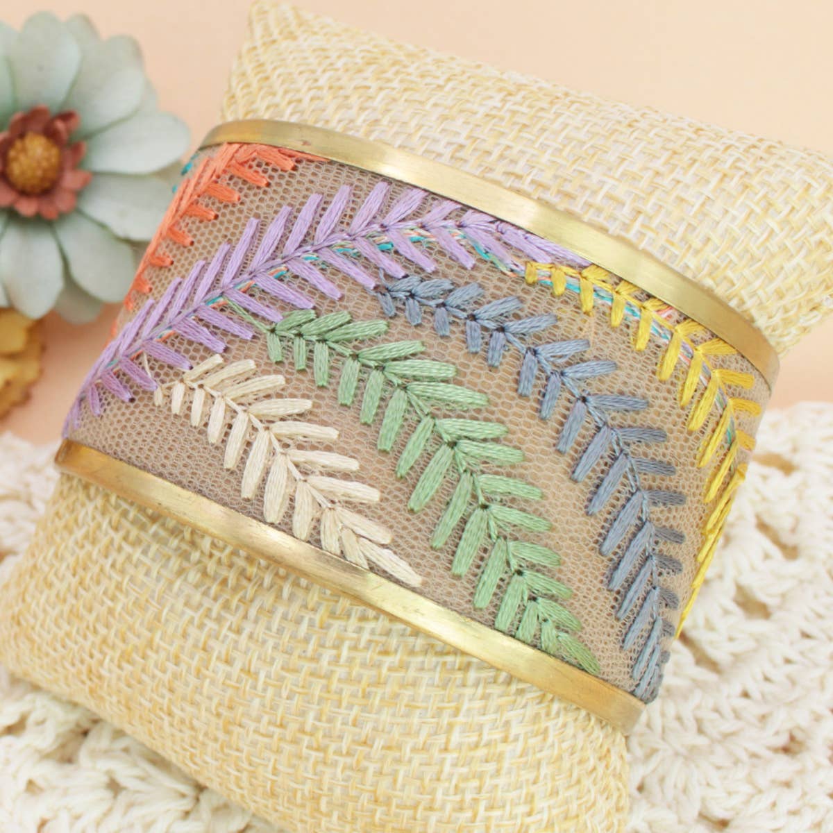 Decorative bracelet with embroidered pattern on a textured surface
