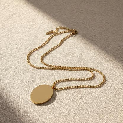 Image of the back side of the gold necklace on a light gray background