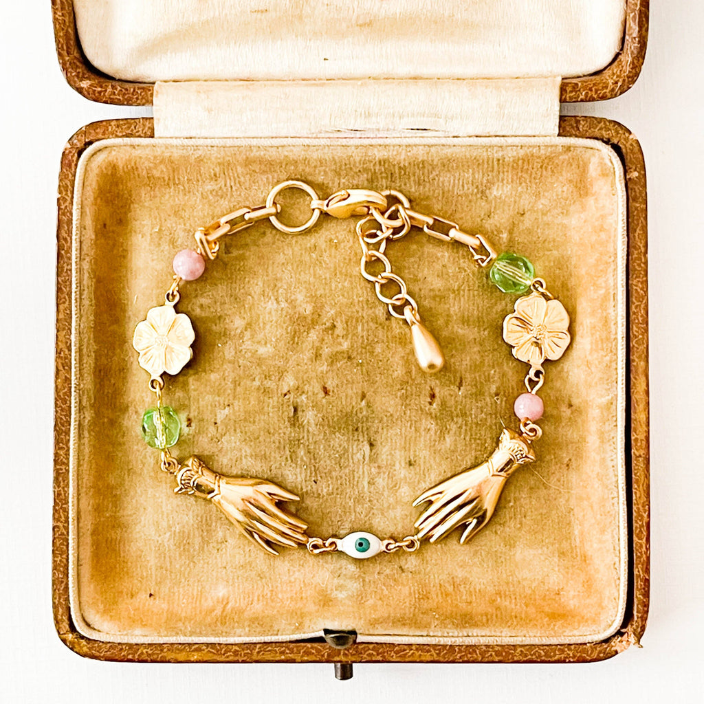 Adjustable spring bracelet with golden brass flowers and soft pink and lavender beads