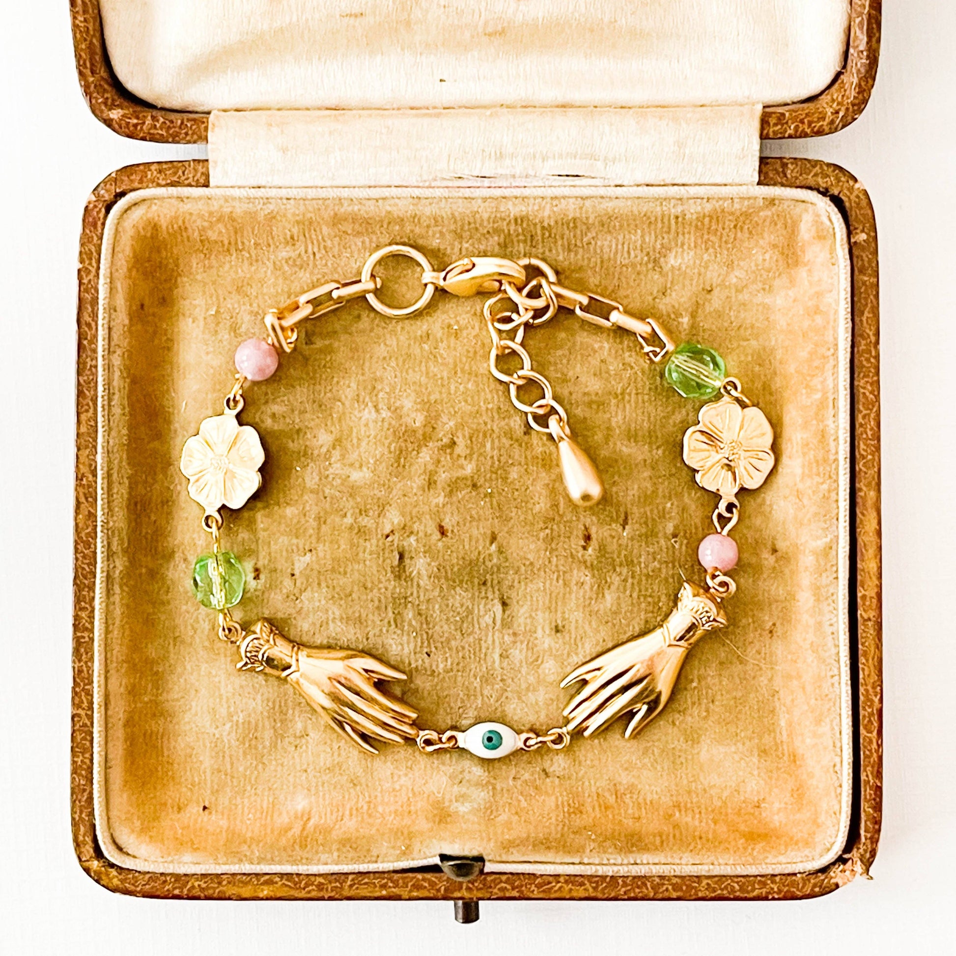 Adjustable spring bracelet with golden brass flowers and soft pink and lavender beads