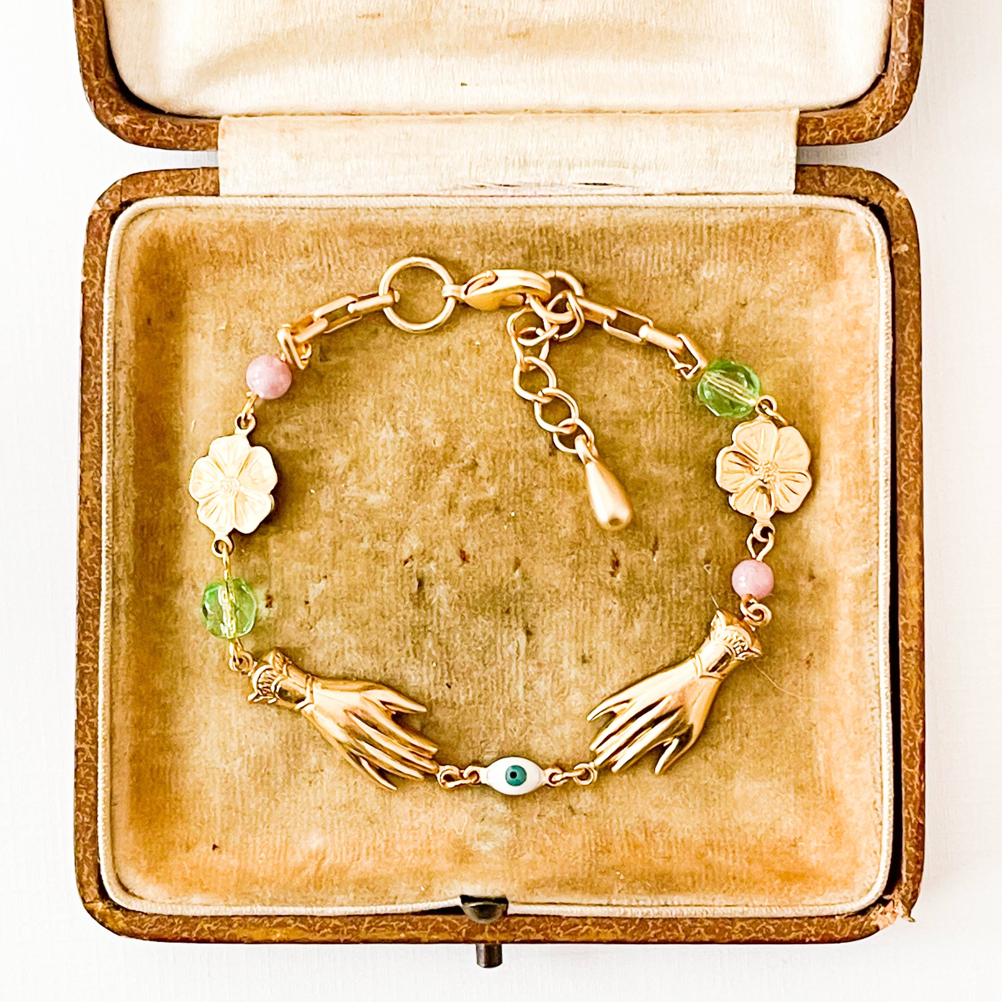 Adjustable spring bracelet with golden brass flowers and soft pink and lavender beads