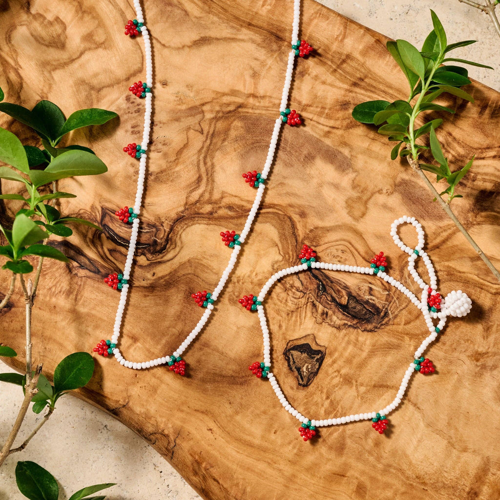 Artisan-crafted strawberry-themed bracelet with bright red and green beads against a neutral background
