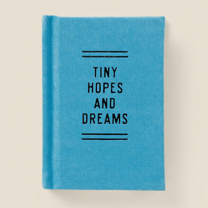 Mini blue notebook with 'Tiny Hopes and Dreams' text on a white background