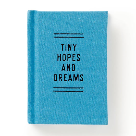 Blue notebook with 'Tiny Hopes and Dreams' text on a white background
