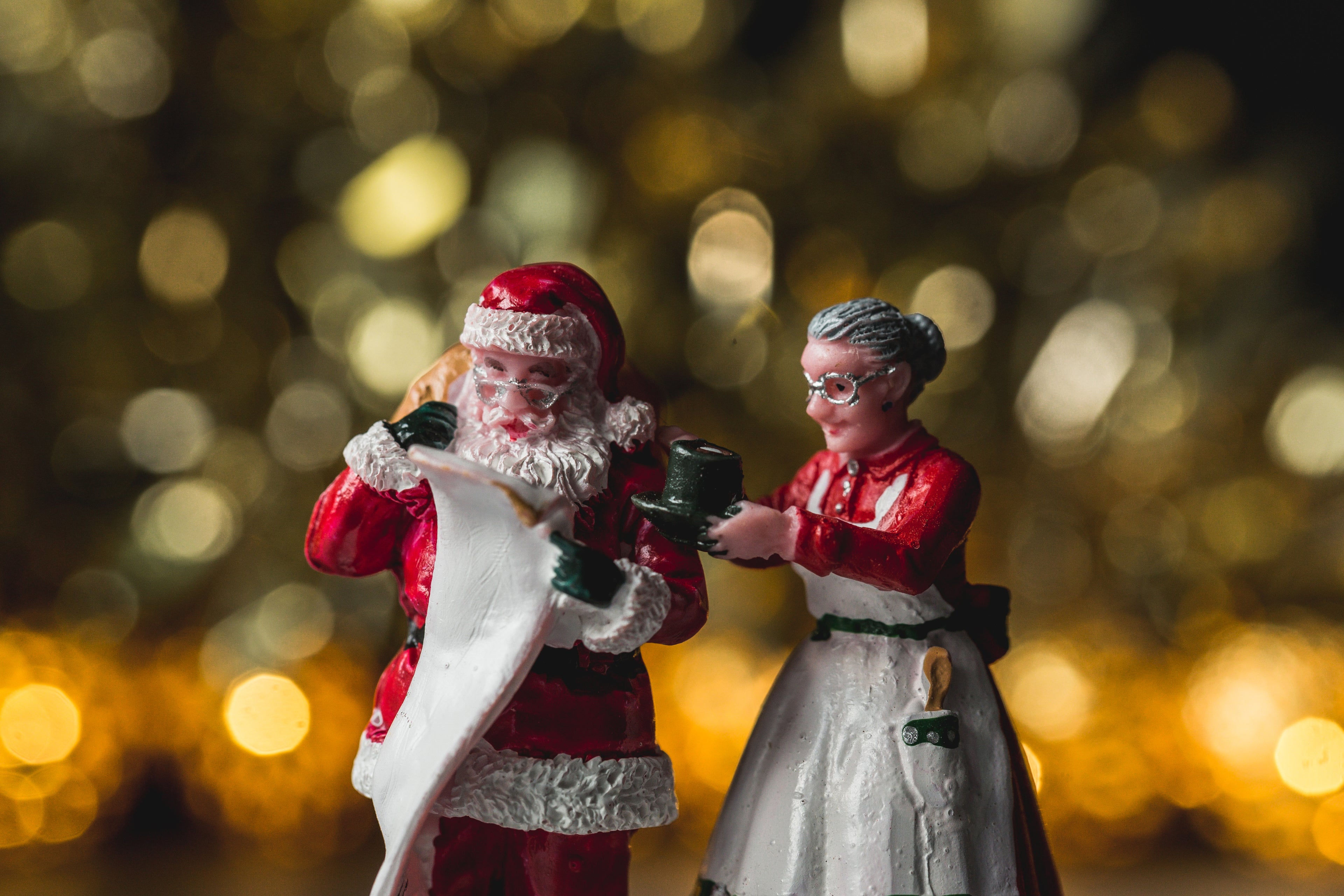 Image of Santa Clause and Mrs. Clause figurines with a holiday background