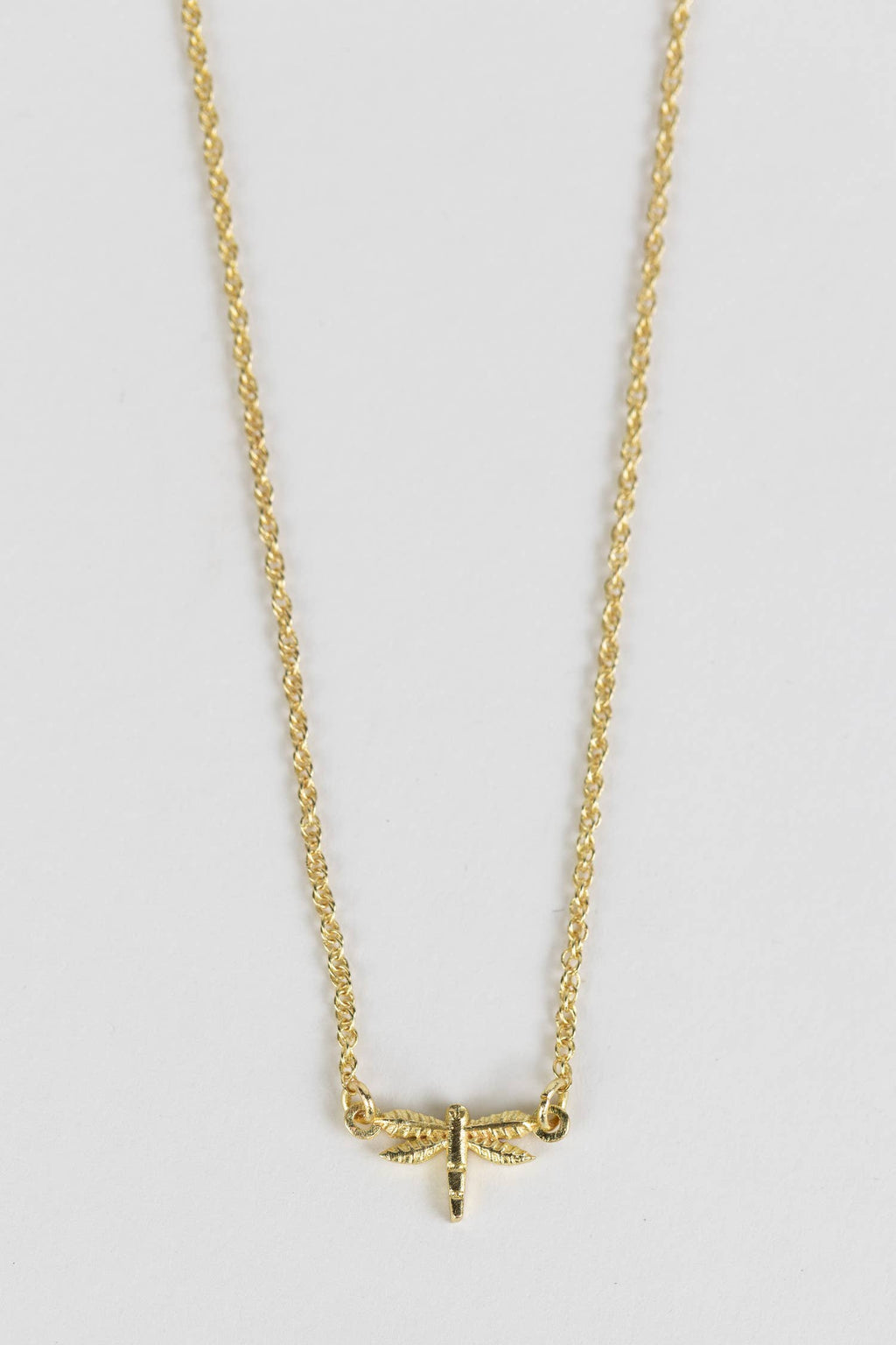 Minimalist dragonfly necklace styled as a meaningful everyday accessory