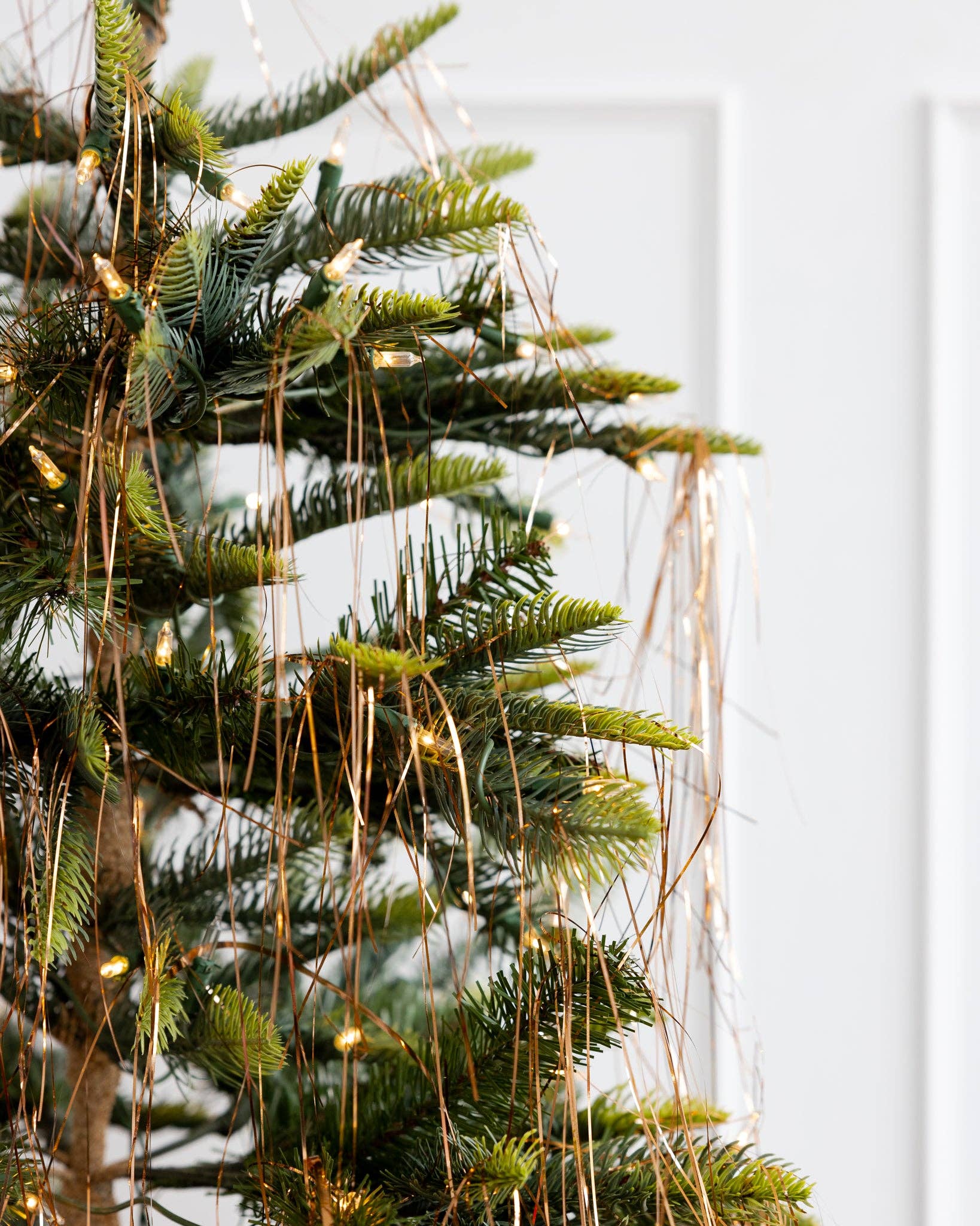 Bronze tinsel strands draped across a Christmas tree for a vintage look