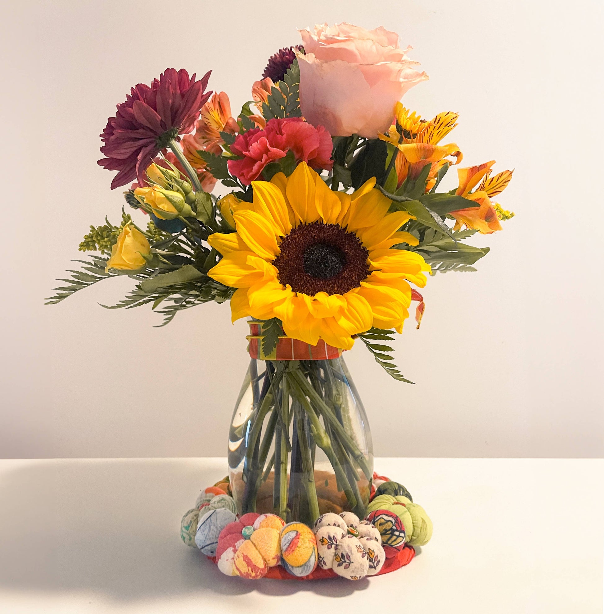 Bouquet of flowers in a clear vase on a white surface with a white background