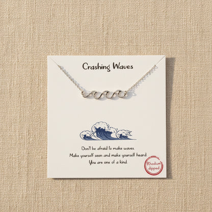 Rhodium dipped necklace with 'Crashing Waves' design on a white card with text and branding.