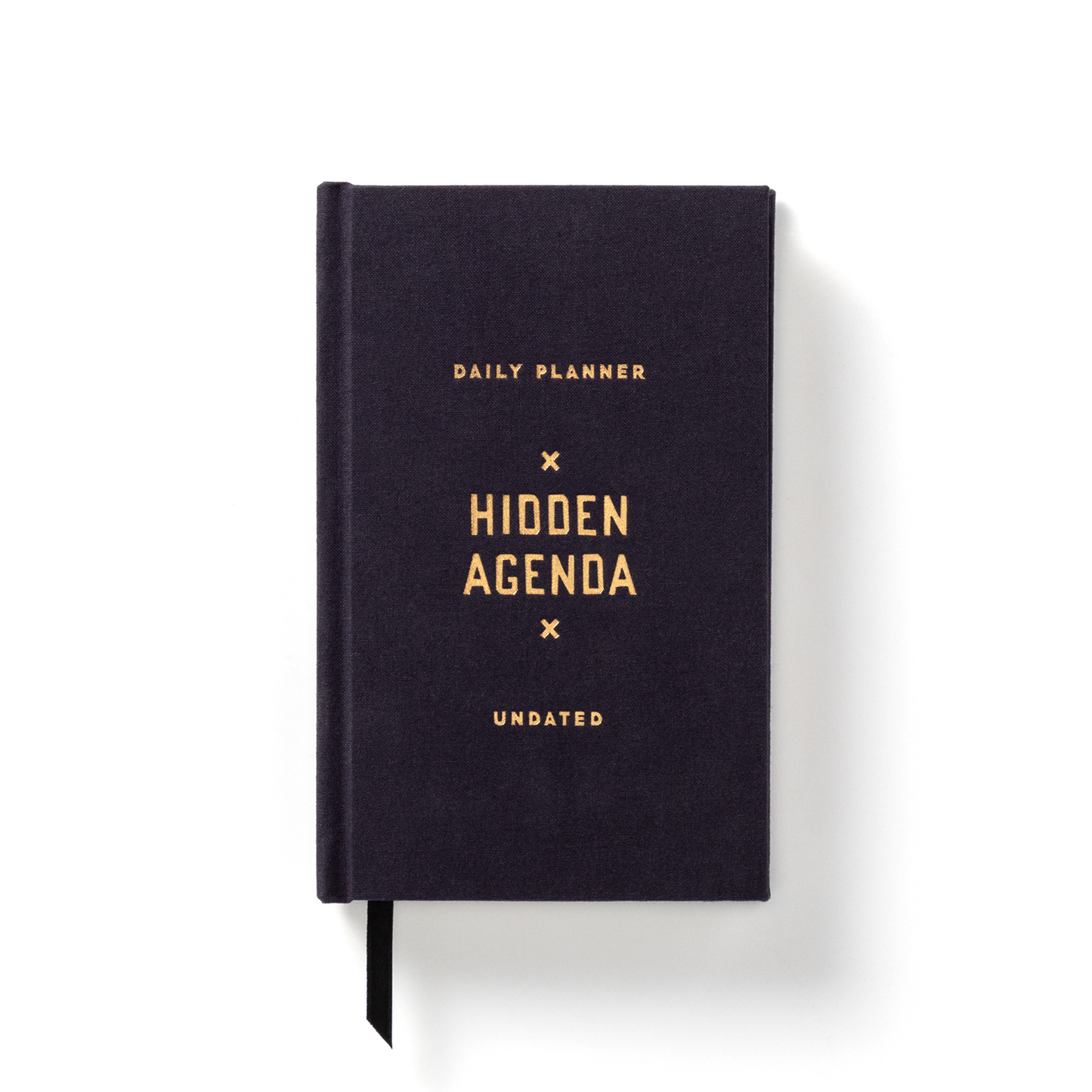 Cloth-bound Hidden Agenda planner with embossed cover design