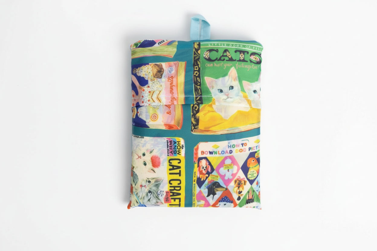 Back view of the Useless Books Art Sack by Anna Hoyle folded up with a white background.