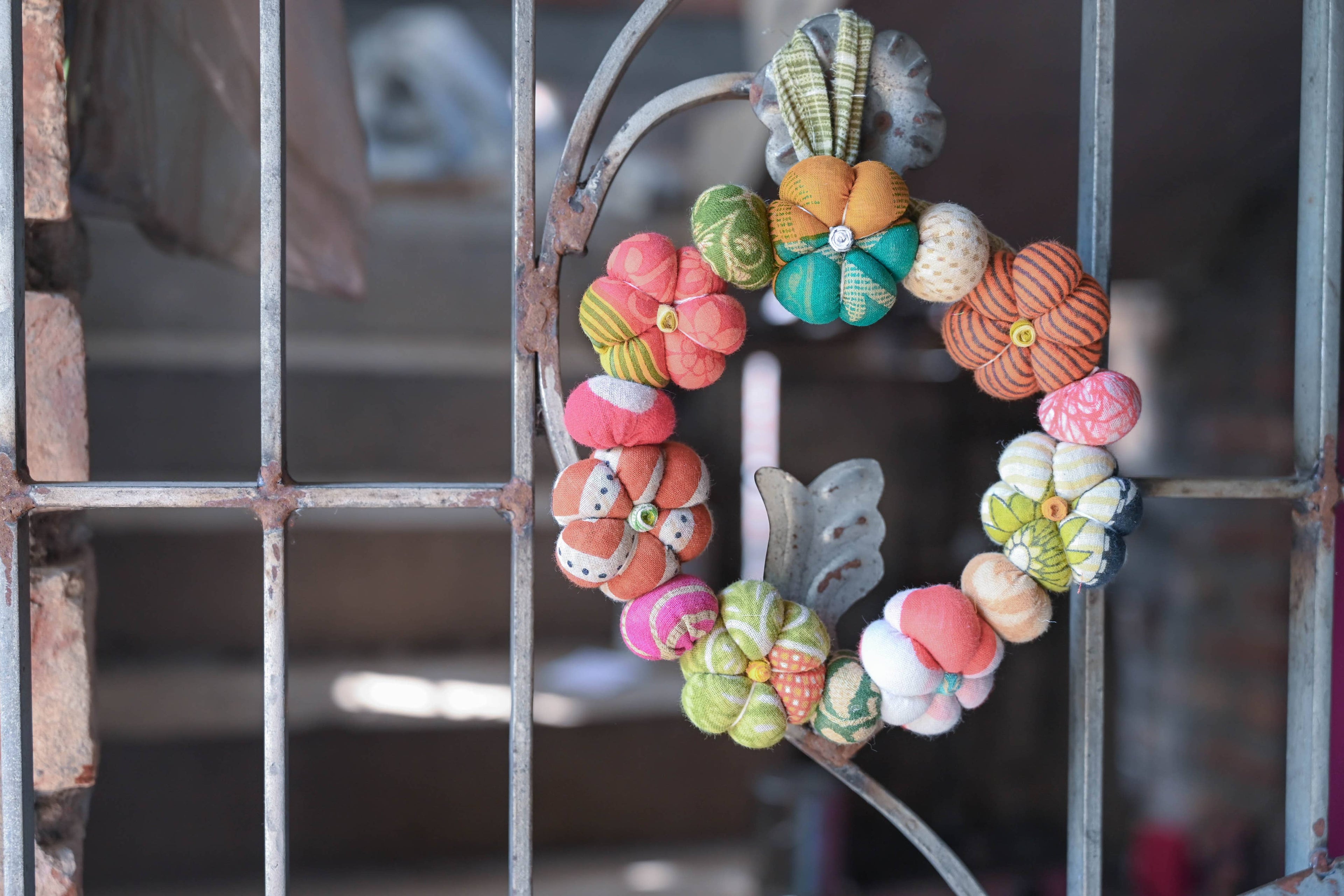 Decorative wreath with colorful flowers on a metal grid background