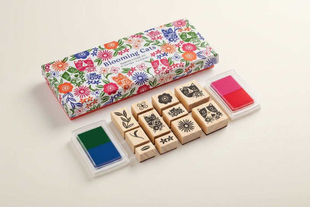 Set of wooden stamps with floral packaging and ink pads on a white background