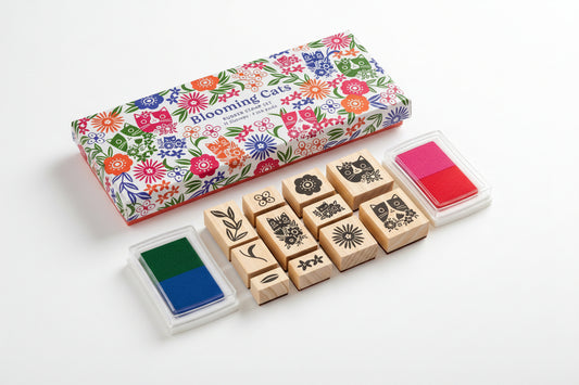 Set of wooden stamps with floral packaging and ink pads on a white background