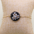 Bracelet with floral design on a textured beige surface