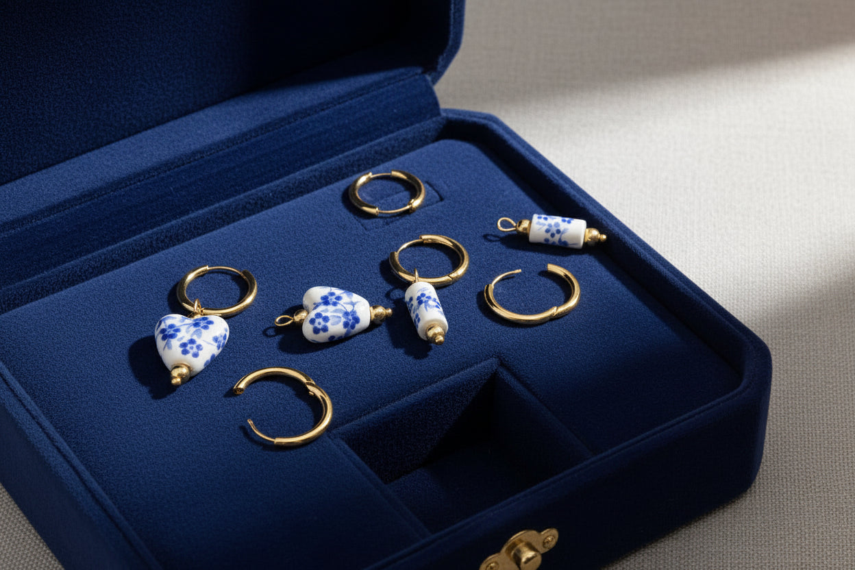 Set of gold and ceramic earrings in a blue jewelry box