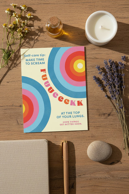 Colorful self care card from Rochambeau Home Gifts on a wooden desk top with natural elements in the background.
