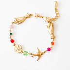 Handmade evil eye charm bracelet featuring pearl, coral, and colorful glass beads on white background