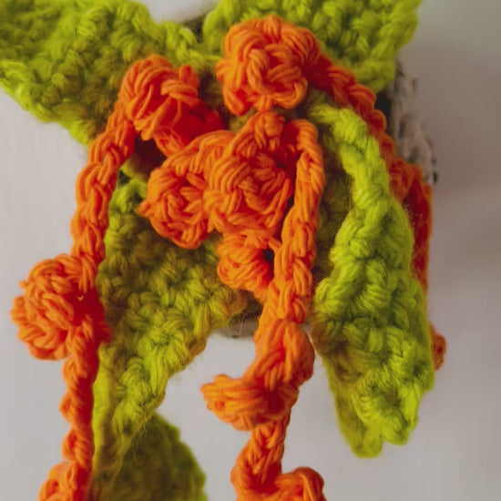 Whimsical crochet plant in vivid tropical colors perched in a neutral pot