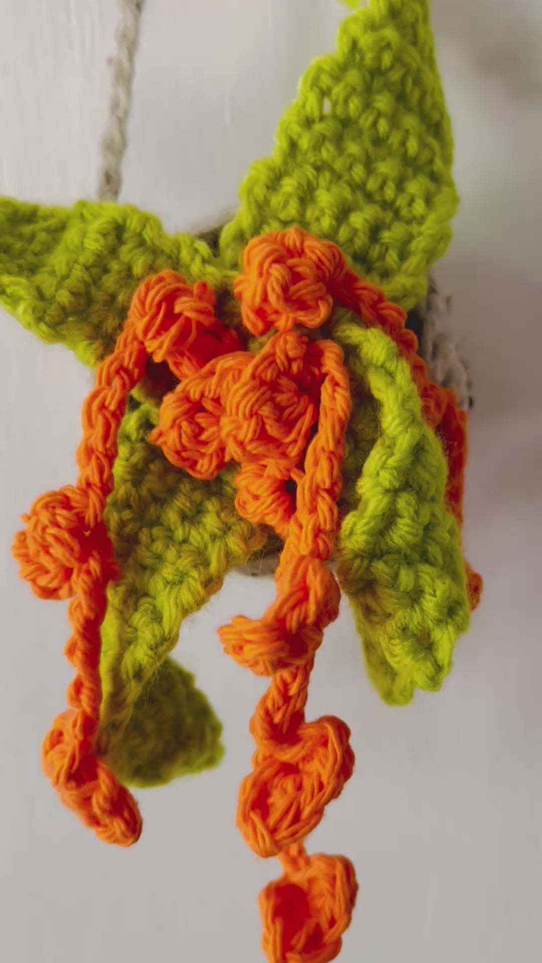 Whimsical crochet plant in vivid tropical colors perched in a neutral pot